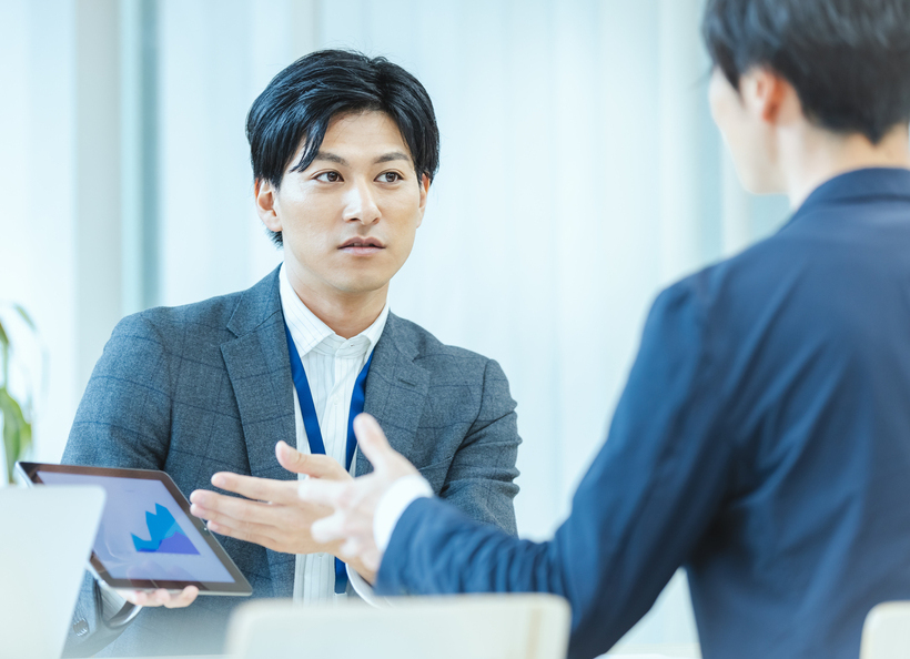 男性がiPadで説明をしている画像