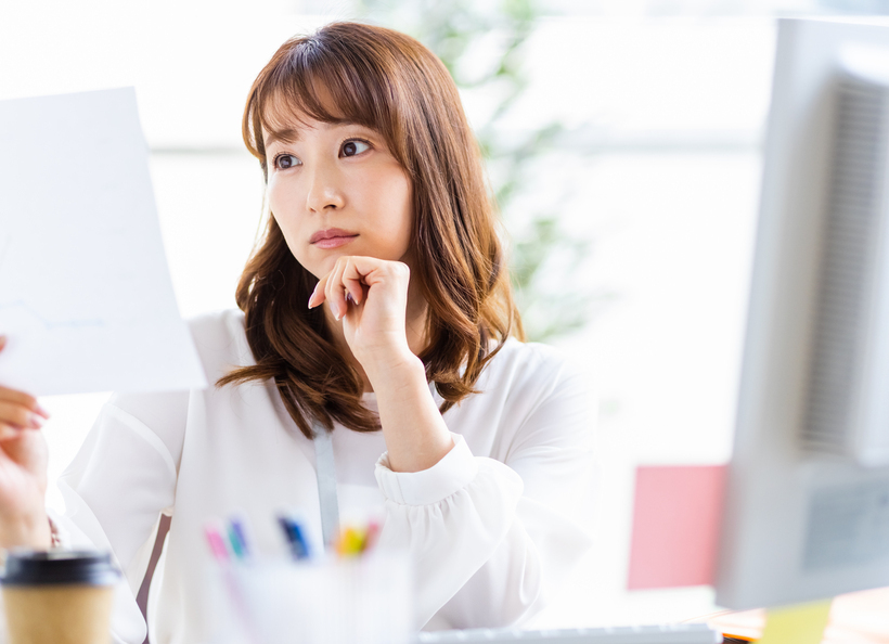 女性が用紙を見ている画像