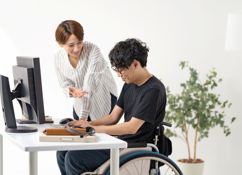 車椅子の男性と話す女性の画像