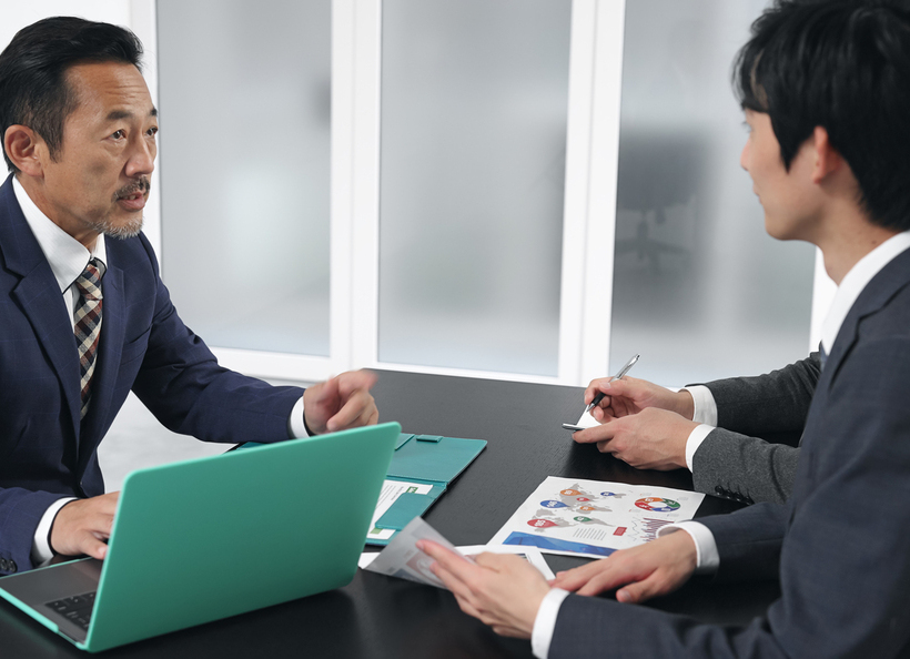 男性が2名の男性に説明をしている画像