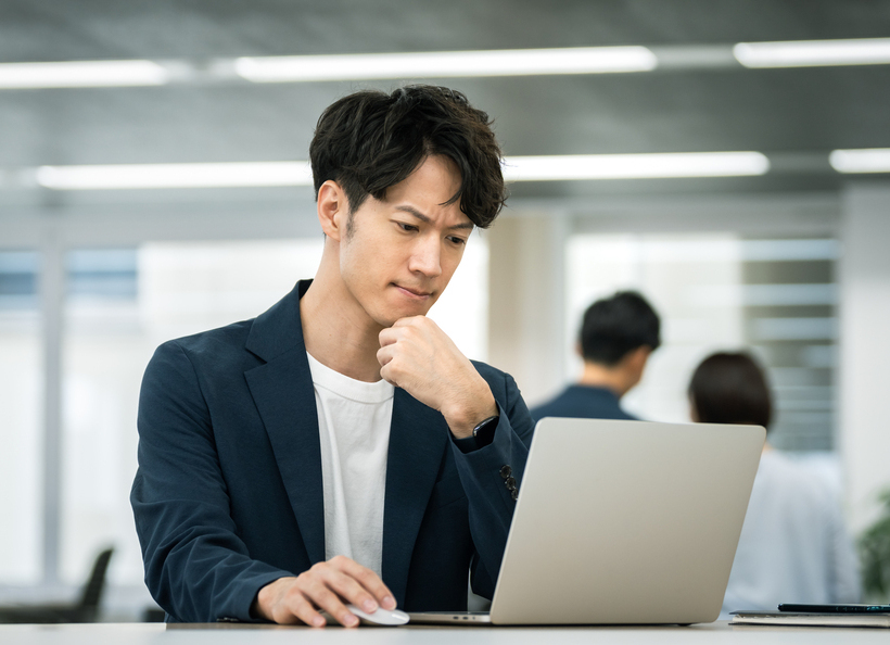 PCを見て考えている画像