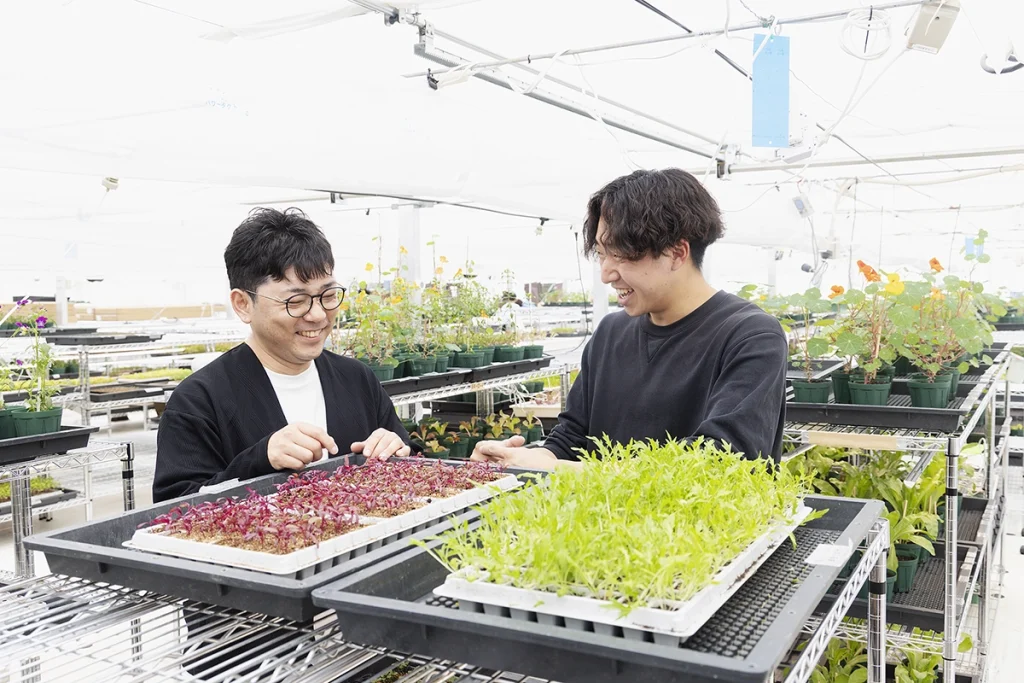 農園内で笑顔で話す叶内氏と農園マネージャーの写真