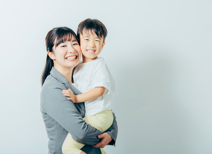 子を抱っこする母親の画像