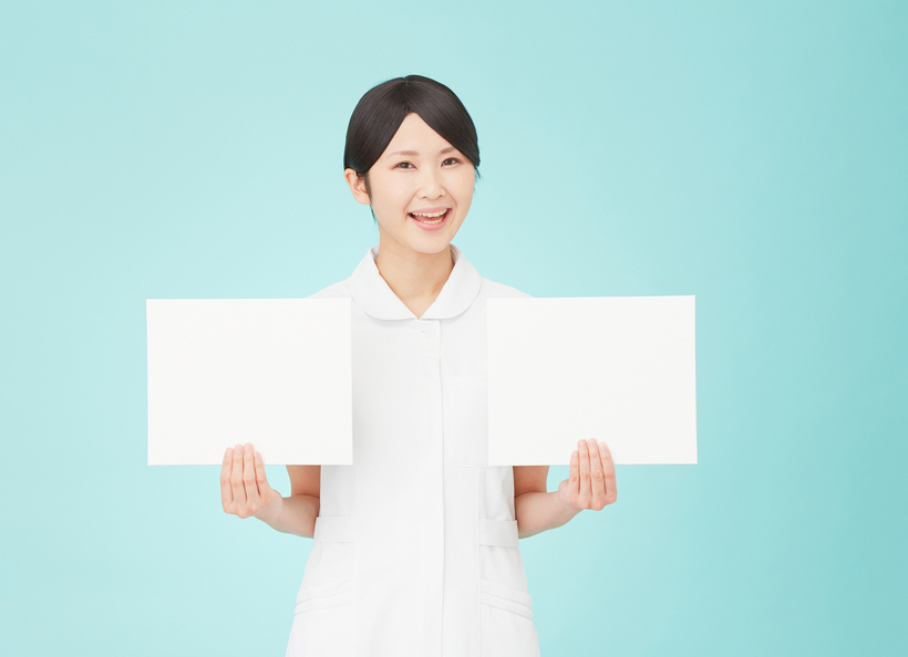 看護師が紙を持っている画像